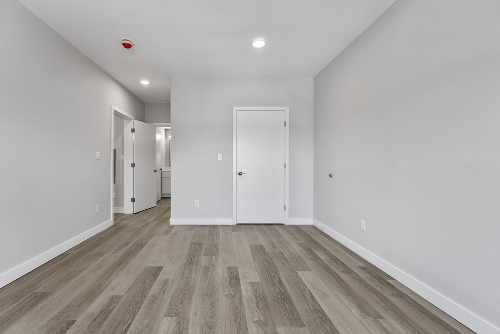 59 Mill Street, Unit 203 Woburn, MA 01801 - Photo 18 of 19 a view of an empty room with wooden floor
