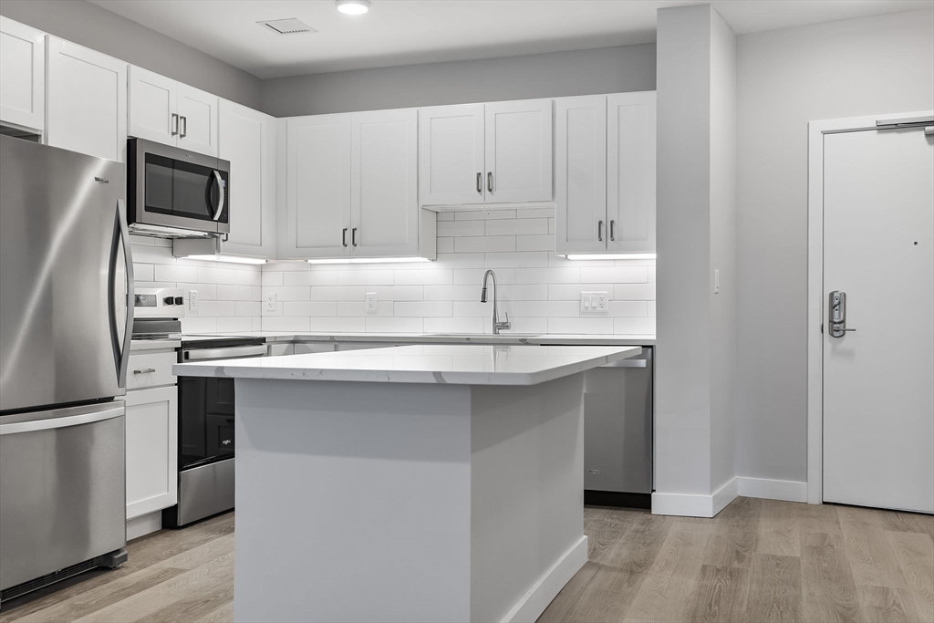 59 Mill Street, Unit 203 Woburn, MA 01801 - Photo 5 of 19 a kitchen with appliances a sink and cabinets