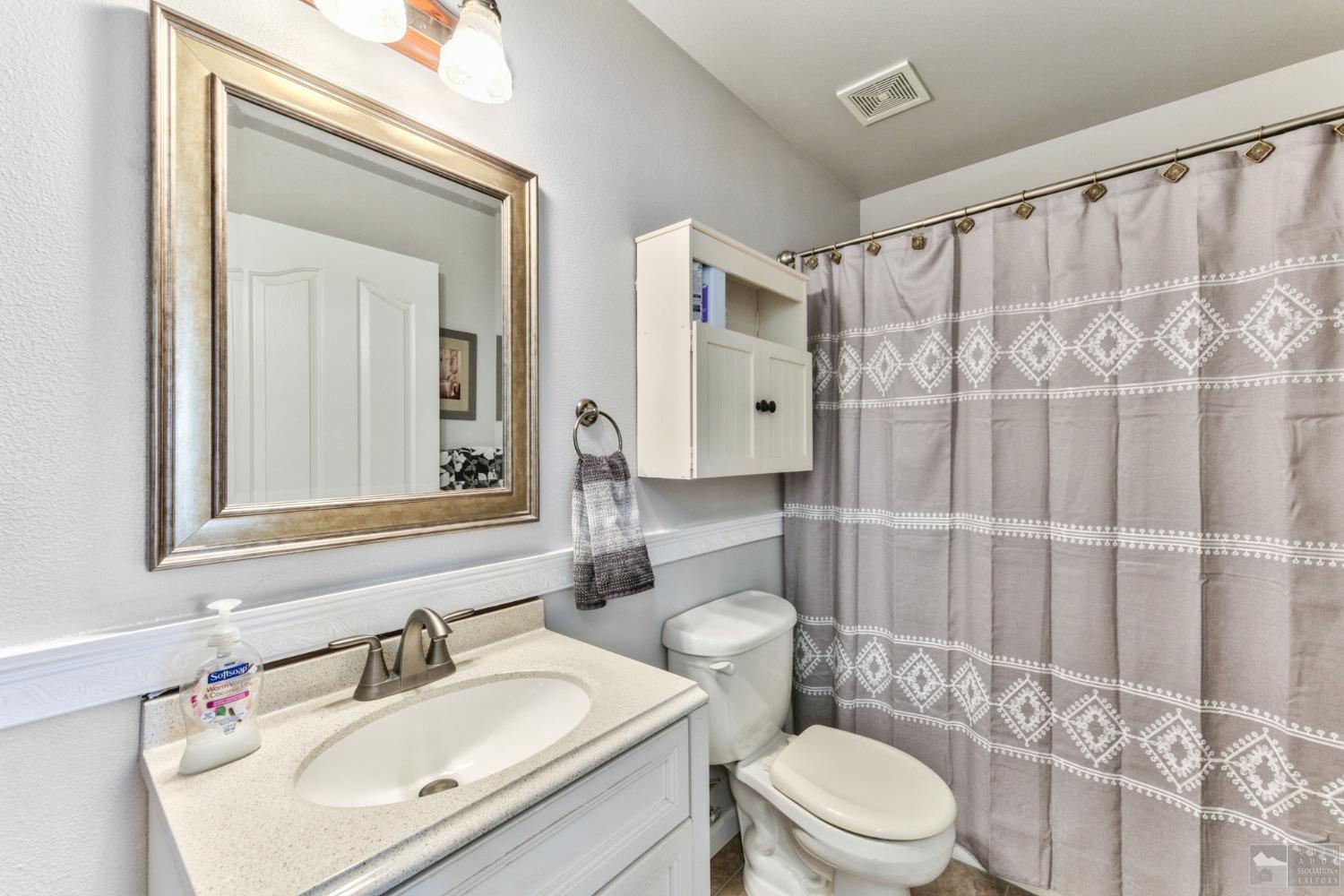 1111 Foothill Road Markleeville, CA 96120 - Photo 24 of 28 a bathroom with a sink a toilet a mirror and shower curtain