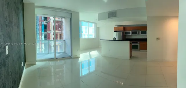 a kitchen with stainless steel appliances kitchen island granite countertop a refrigerator and a sink