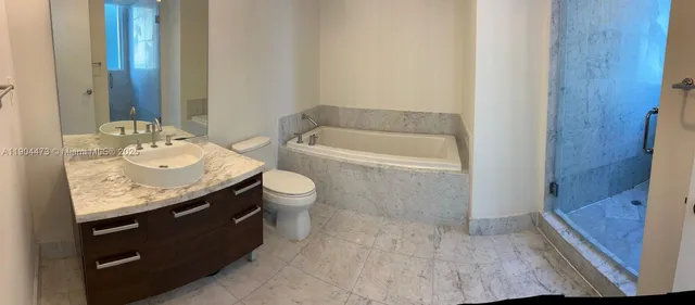 a bathroom with a granite countertop sink a toilet and bathtub