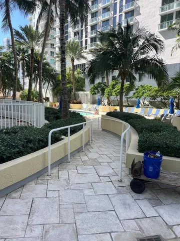 a view of a patio with table and chairs potted plants and palm trees