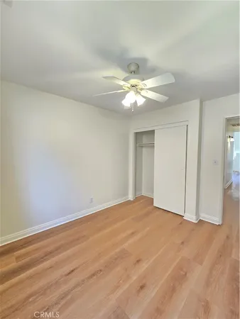 a view of an empty room with chandelier fan and a window
