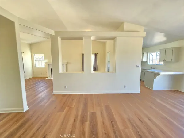 a view of a room with wooden floor and white walls