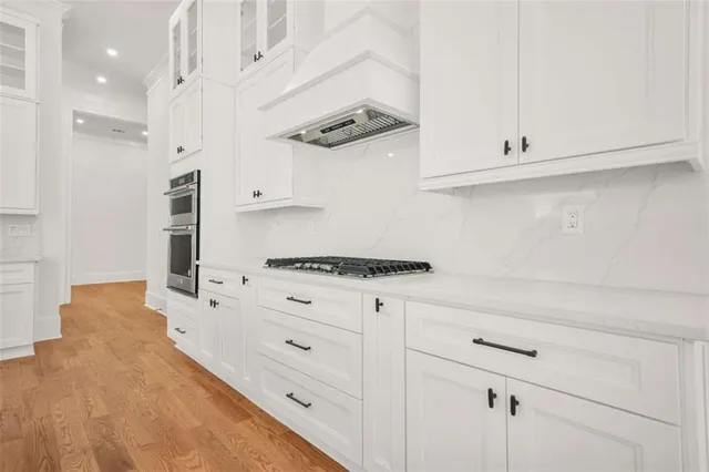 an empty room with wooden floor ceiling fan and windows