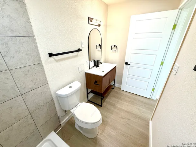 a bathroom with a sink a toilet and a mirror