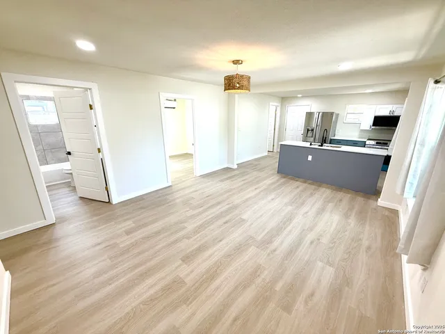 a view of a living room with a sink and wooden floor