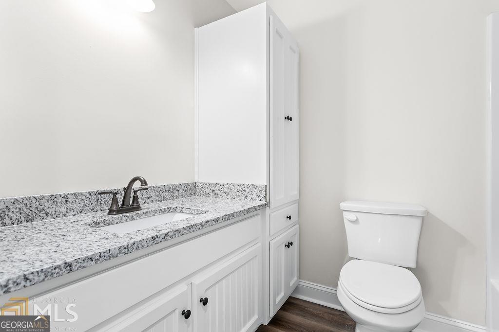 3077 Alec Mountain Road Clarkesville, GA 30523 - Photo 19 of 35 a bathroom with a granite countertop toilet sink and mirror