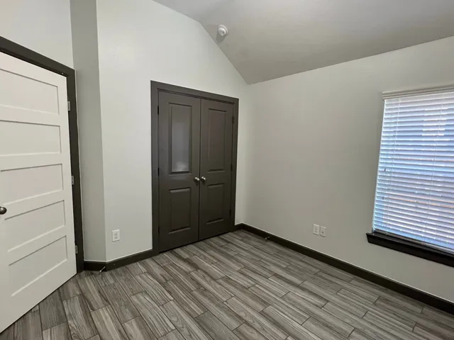 a view of empty room with wooden floor