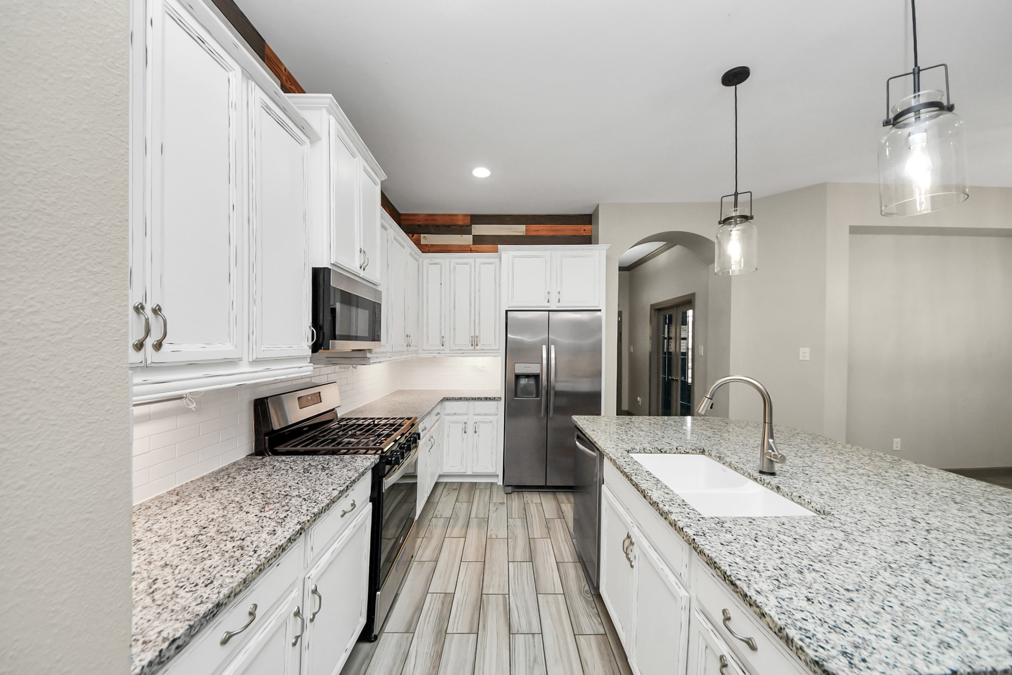 211 Pleasant Hill Way Conroe, TX 77304 - Photo 12 of 50 a kitchen with a sink stove and refrigerator