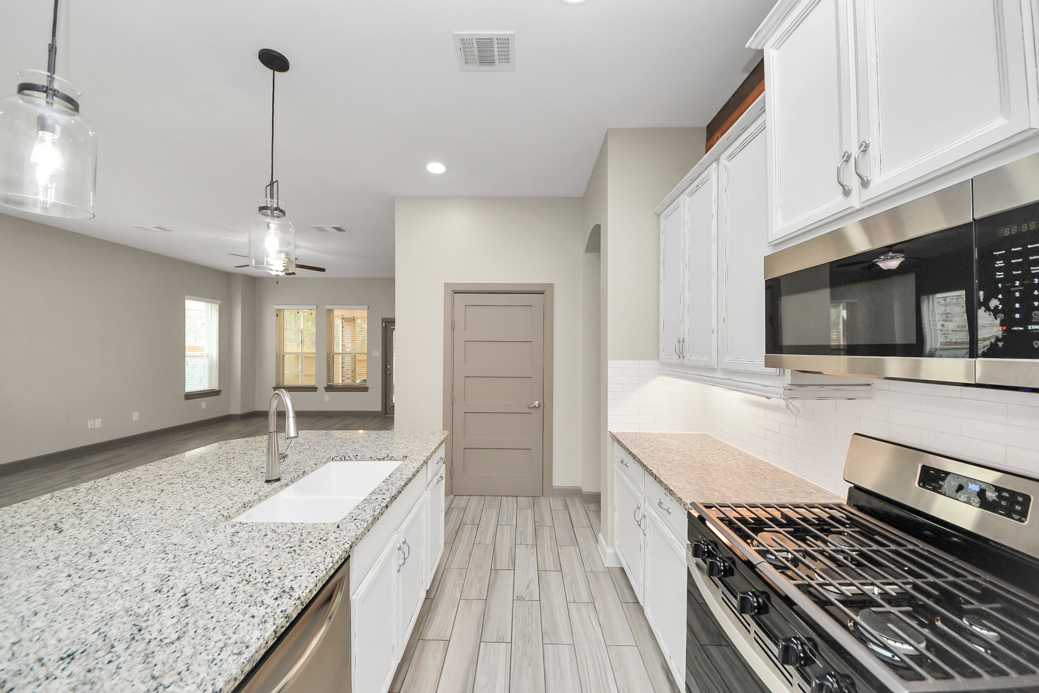 211 Pleasant Hill Way Conroe, TX 77304 - Photo 14 of 50 a large kitchen with granite countertop a sink stove and cabinets
