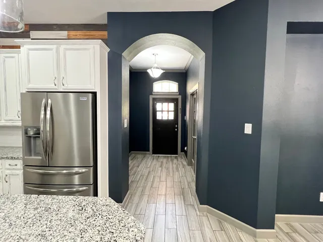 a view of a hallway with wooden floor and staircase
