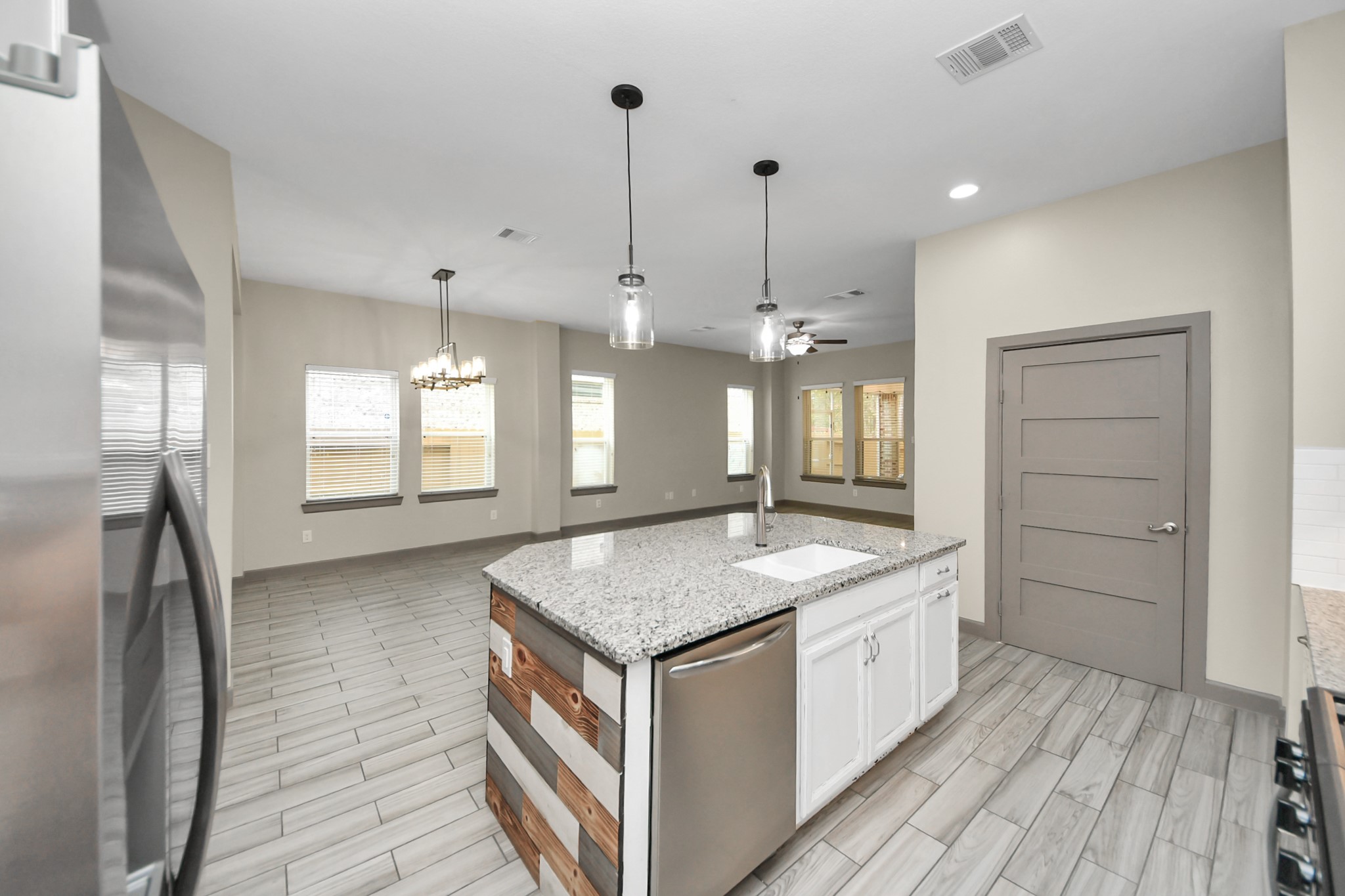 211 Pleasant Hill Way Conroe, TX 77304 - Photo 16 of 50 a kitchen with a stove sink and chandelier