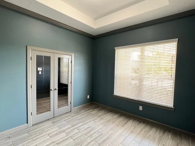 a view of empty room with wooden floor and fan