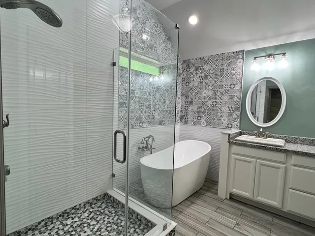 a bathroom with a sink a toilet a mirror and shower