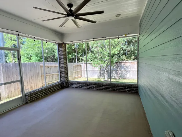 a view of an empty room with a window and a ceiling fan