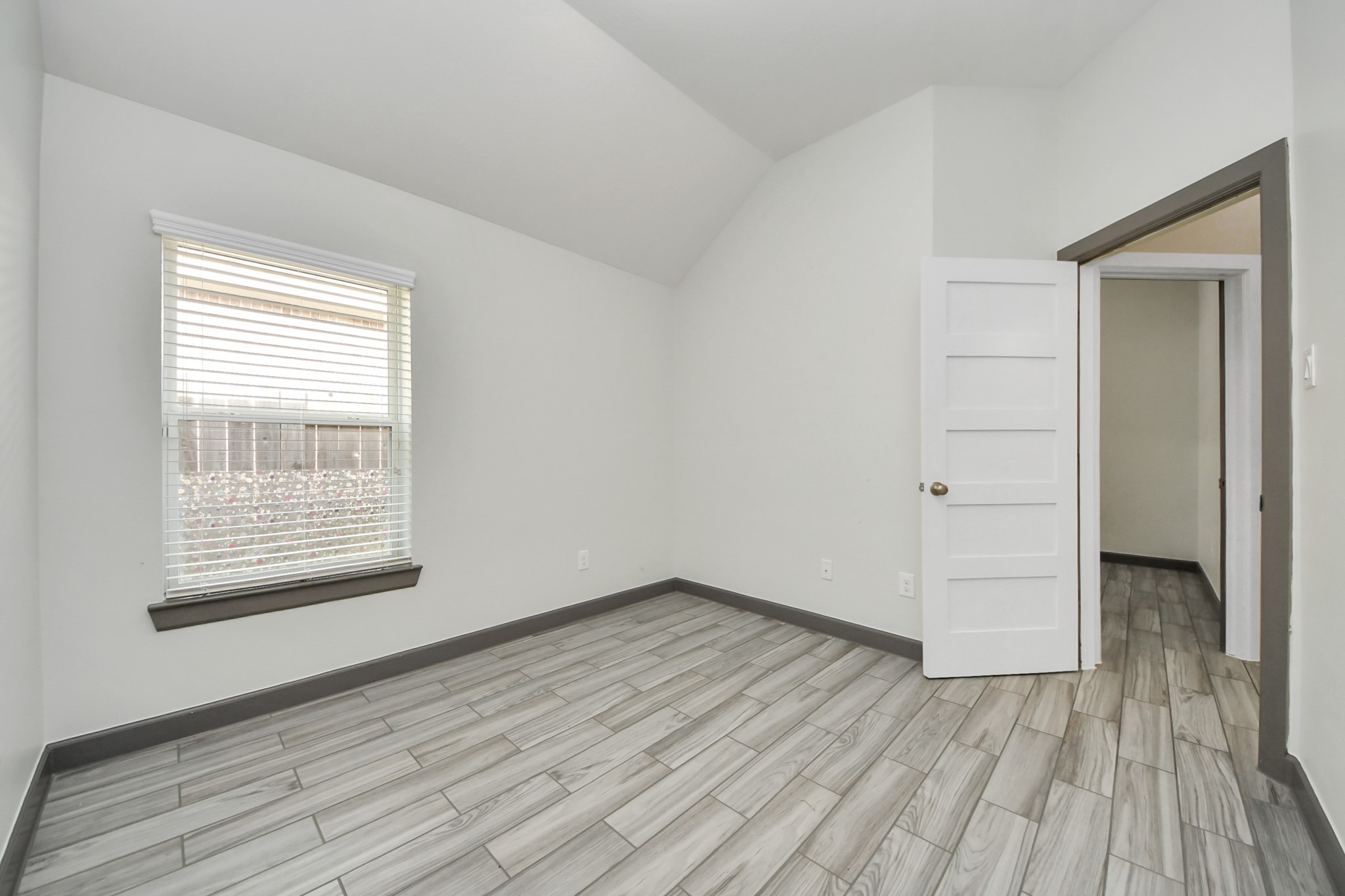211 Pleasant Hill Way Conroe, TX 77304 - Photo 40 of 50 an empty room with wooden floor and windows