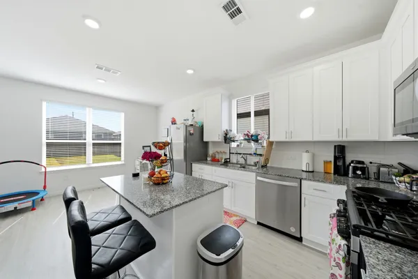 a kitchen with a stove and white cabinets