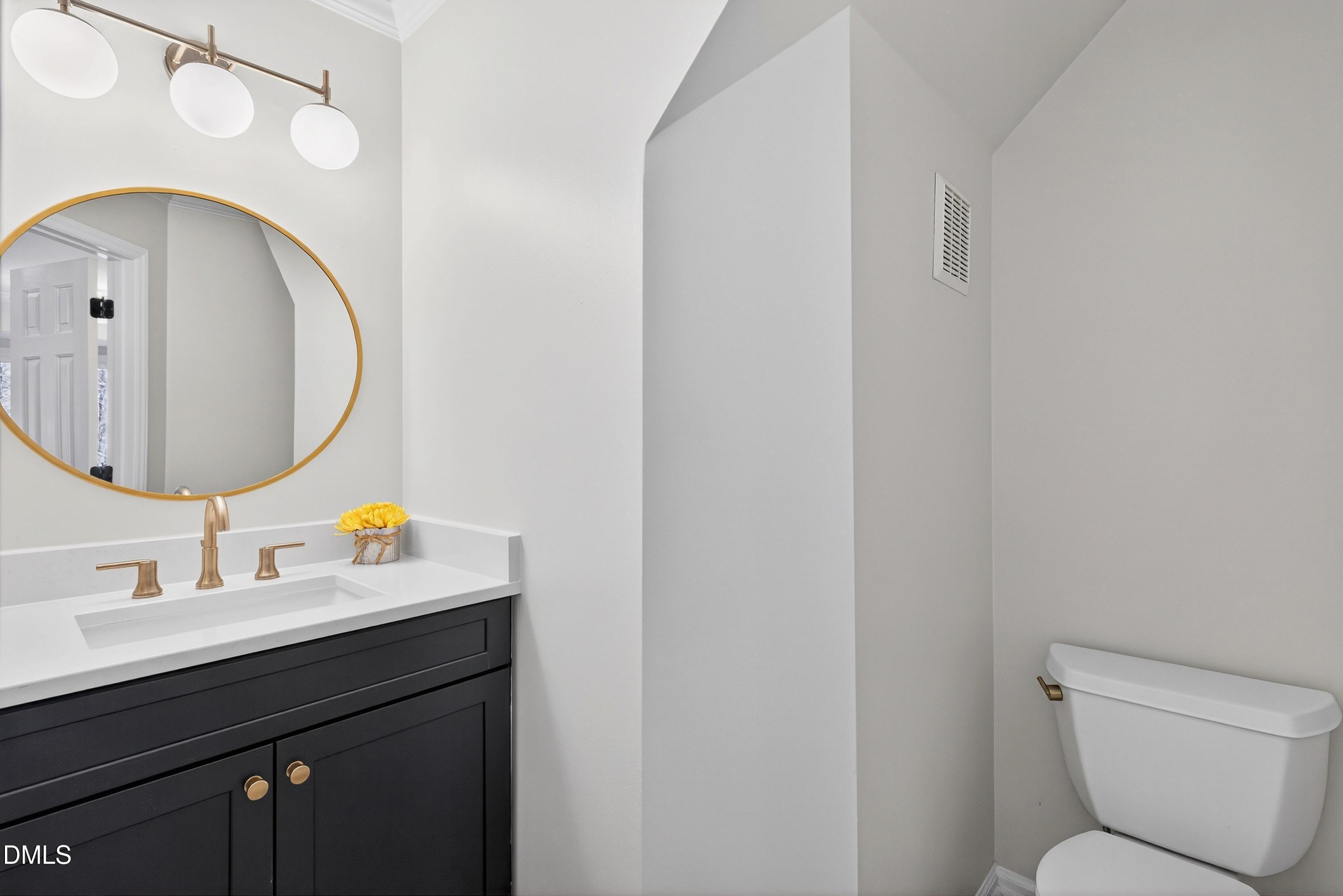 6009 Sweden Drive Raleigh, NC 27612 - Photo 12 of 38 a bathroom with a toilet a sink and mirror