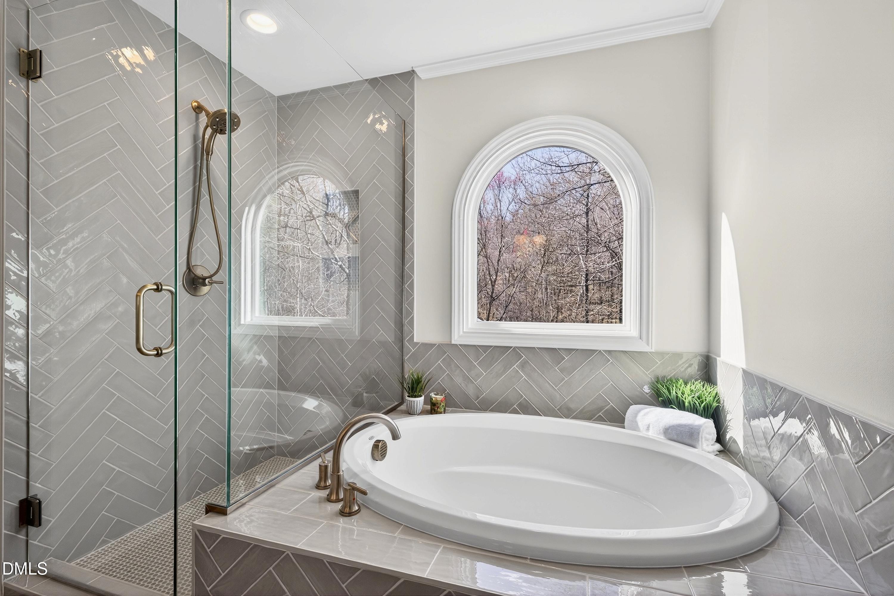 6009 Sweden Drive Raleigh, NC 27612 - Photo 20 of 38 a bathroom with a tub a window and glass door shower