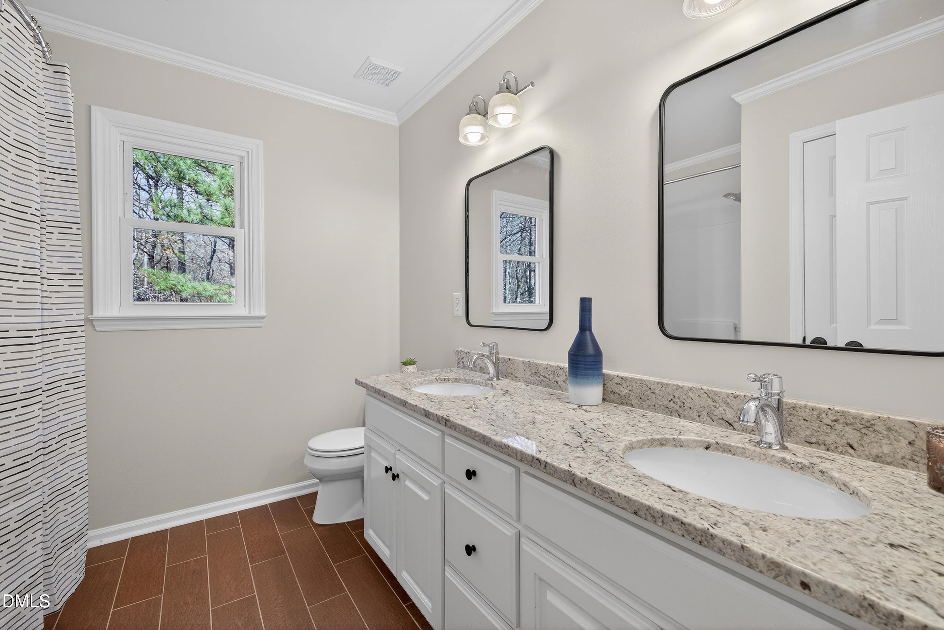 6009 Sweden Drive Raleigh, NC 27612 - Photo 26 of 38 a bathroom with a granite countertop double vanity sink mirror and a toilet