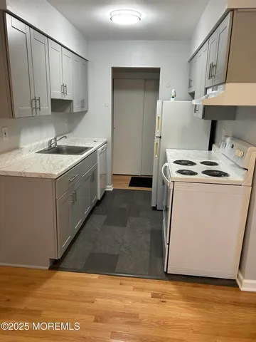 a kitchen with a sink cabinets and wooden floor