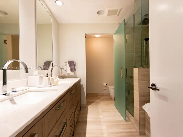a bathroom with a double vanity sink mirror and shower