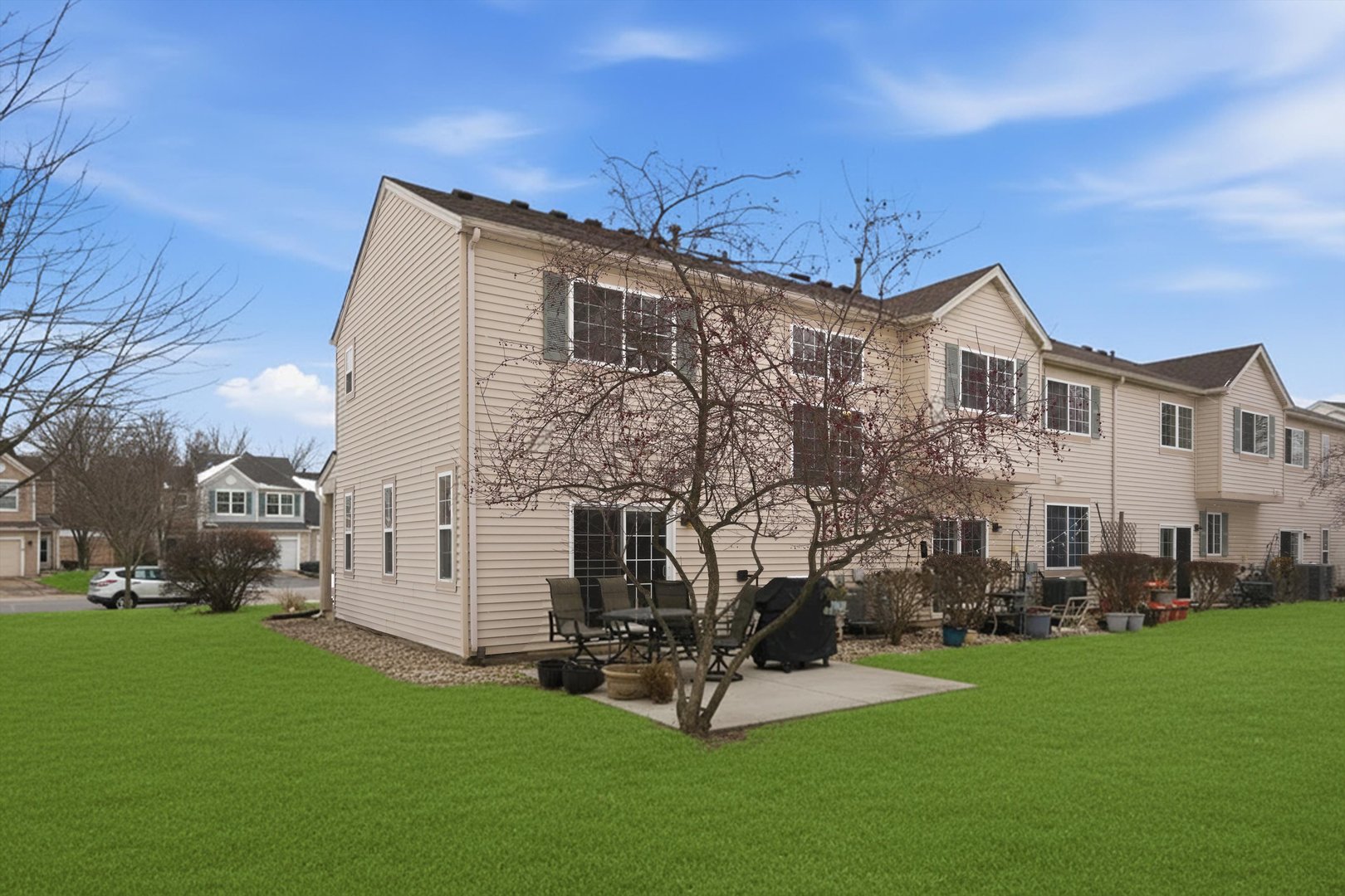 1110 Colonial Drive Joliet, IL 60432 - Photo 6 of 34 a view of a white house next to a yard with big trees