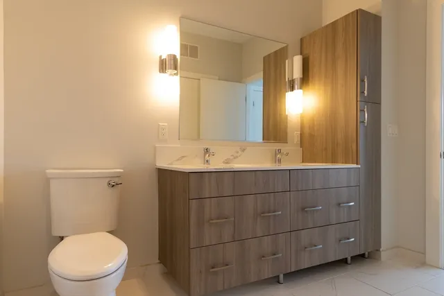 a bathroom with a toilet a sink and mirror