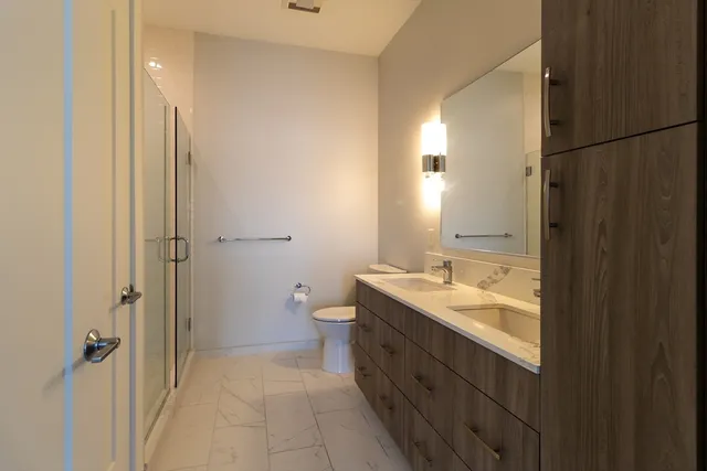 a bathroom with a granite countertop sink a toilet and shower