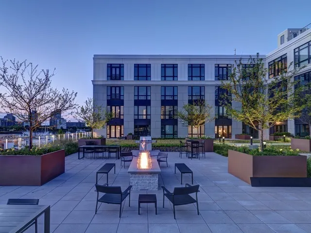 a view of a patio with table and chairs potted plants and a large tree