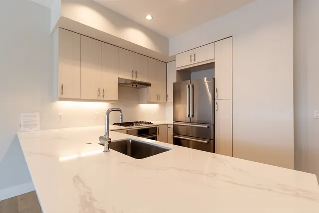 a kitchen with granite countertop a refrigerator stove and sink