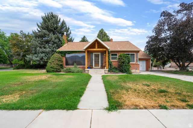 615 East Maple Street Mapleton, UT 84664 - Photo 1 of 30 Brick residence featuring a gabled entry porch with natural wood accents, a shingle roof, and a concrete pathway leading to the entrance