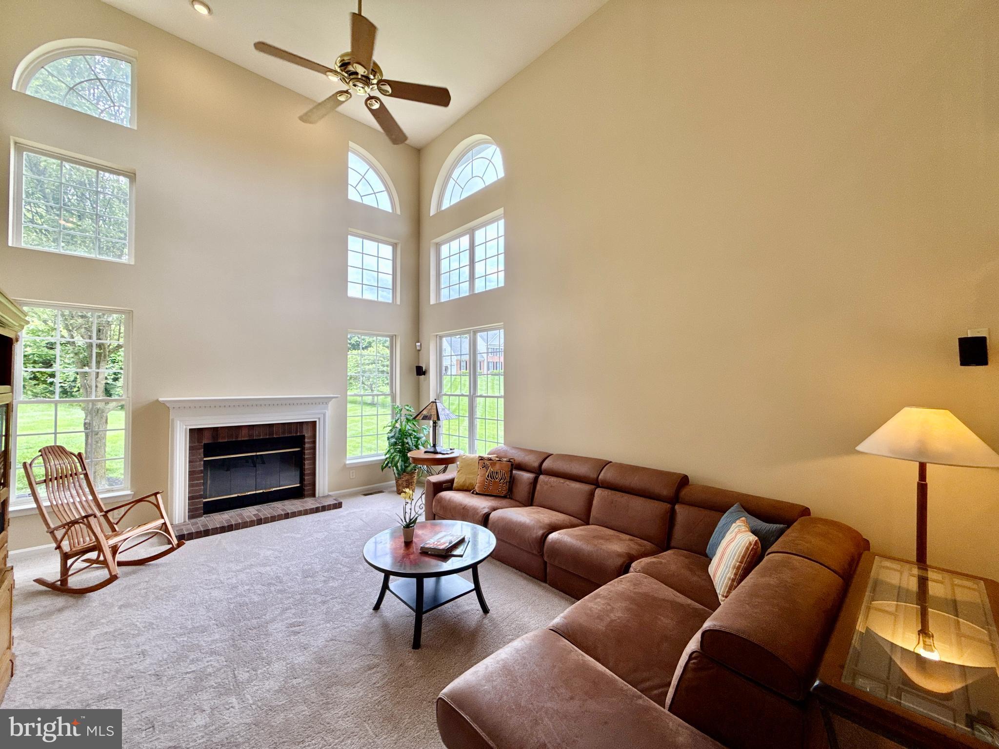 14100 Twisting Lane Dayton, MD 21036 - Photo 16 of 63 a living room with furniture a fireplace and a ceiling fan