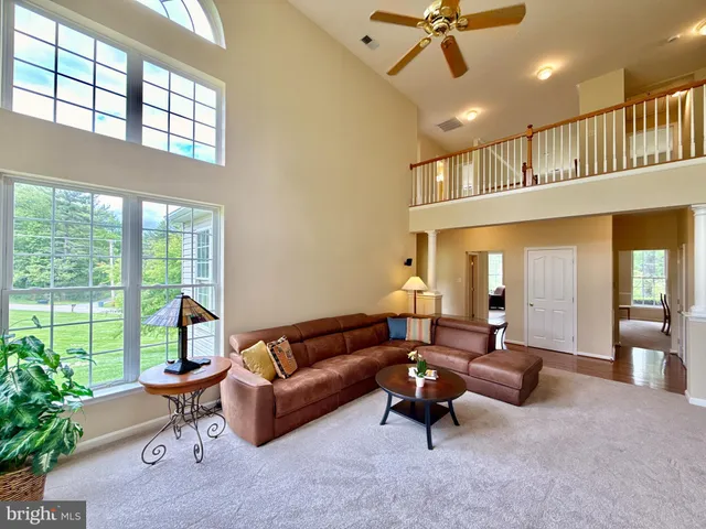 a living room with furniture a ceiling fan and a rug