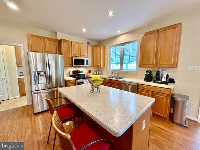 a kitchen with stainless steel appliances granite countertop a refrigerator stove and sink