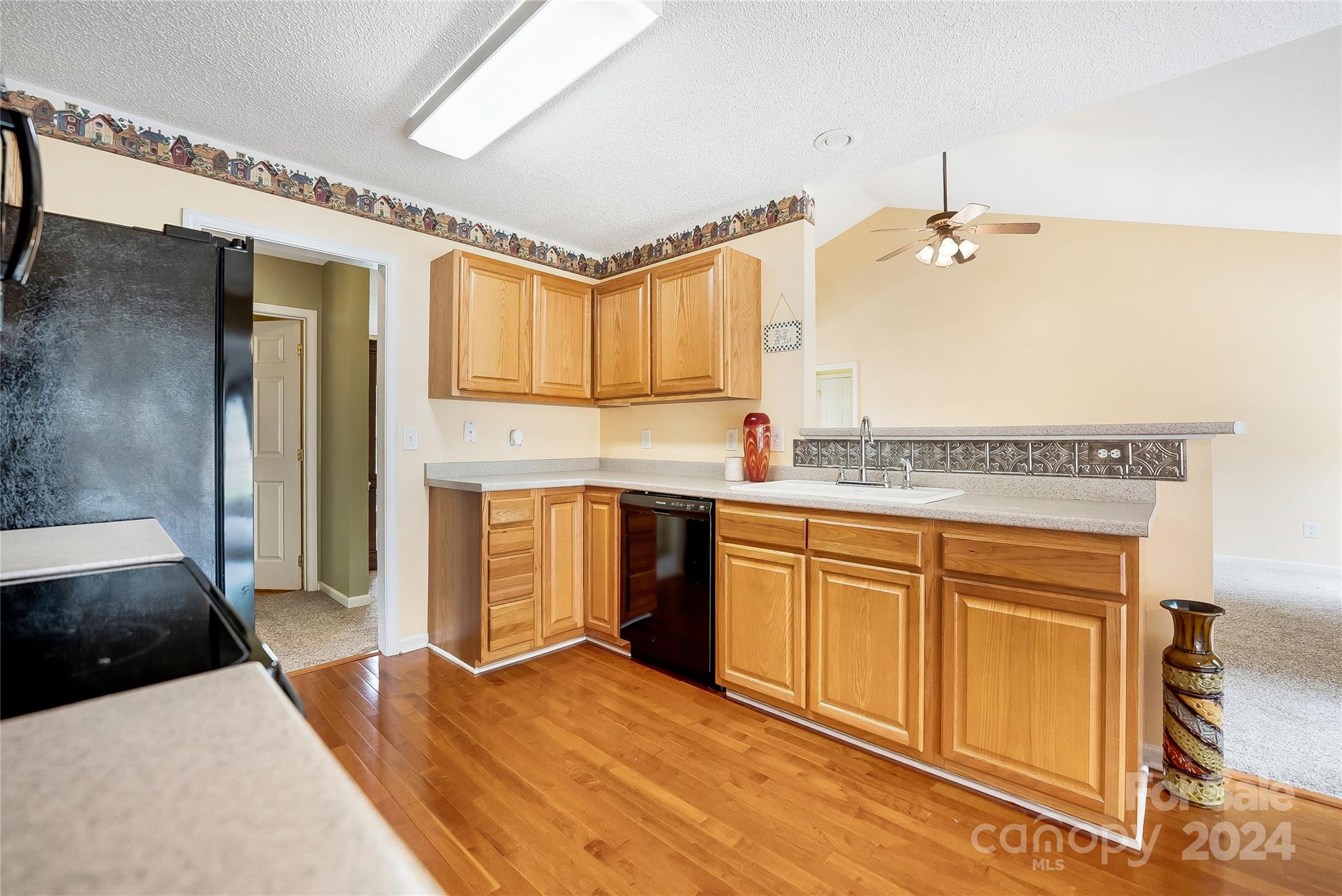 115 English Oak Road Fletcher, NC 28732 - Photo 9 of 30 a kitchen with stainless steel appliances granite countertop a refrigerator a sink dishwasher and wooden cabinets with wooden floor