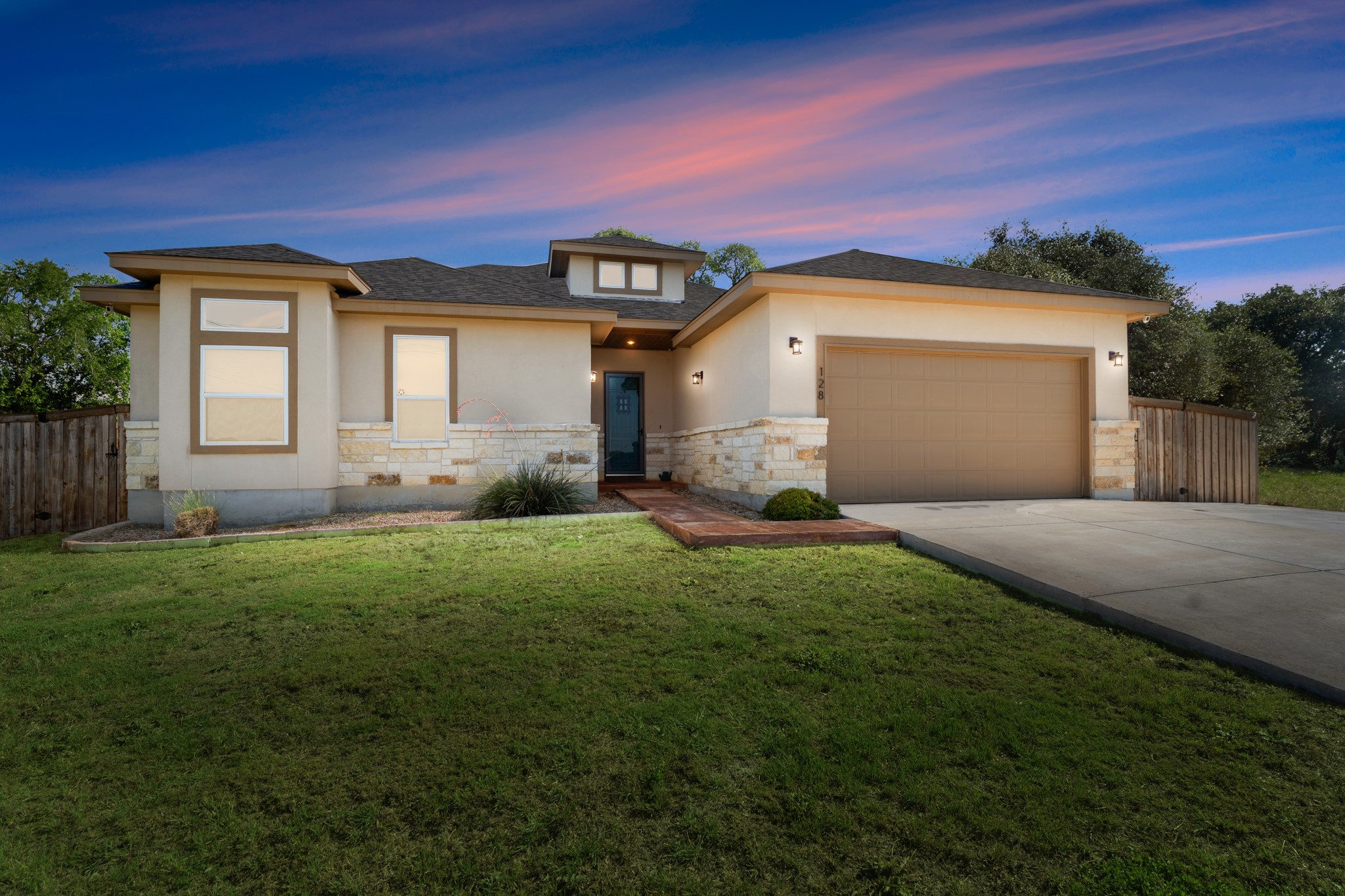 128 Hiram Cook Blanco, TX 78606 - Photo 2 of 40 Contemporary stucco exterior with stone accents and a two-car garage