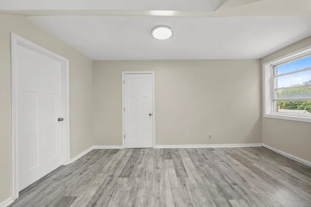 a view of room with window and wooden floor