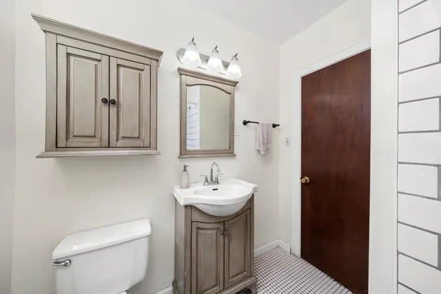 a bathroom with a sink a toilet and mirror