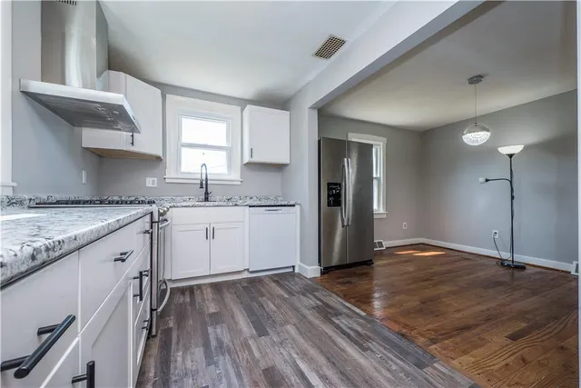 a kitchen with granite countertop white cabinets and white appliances
