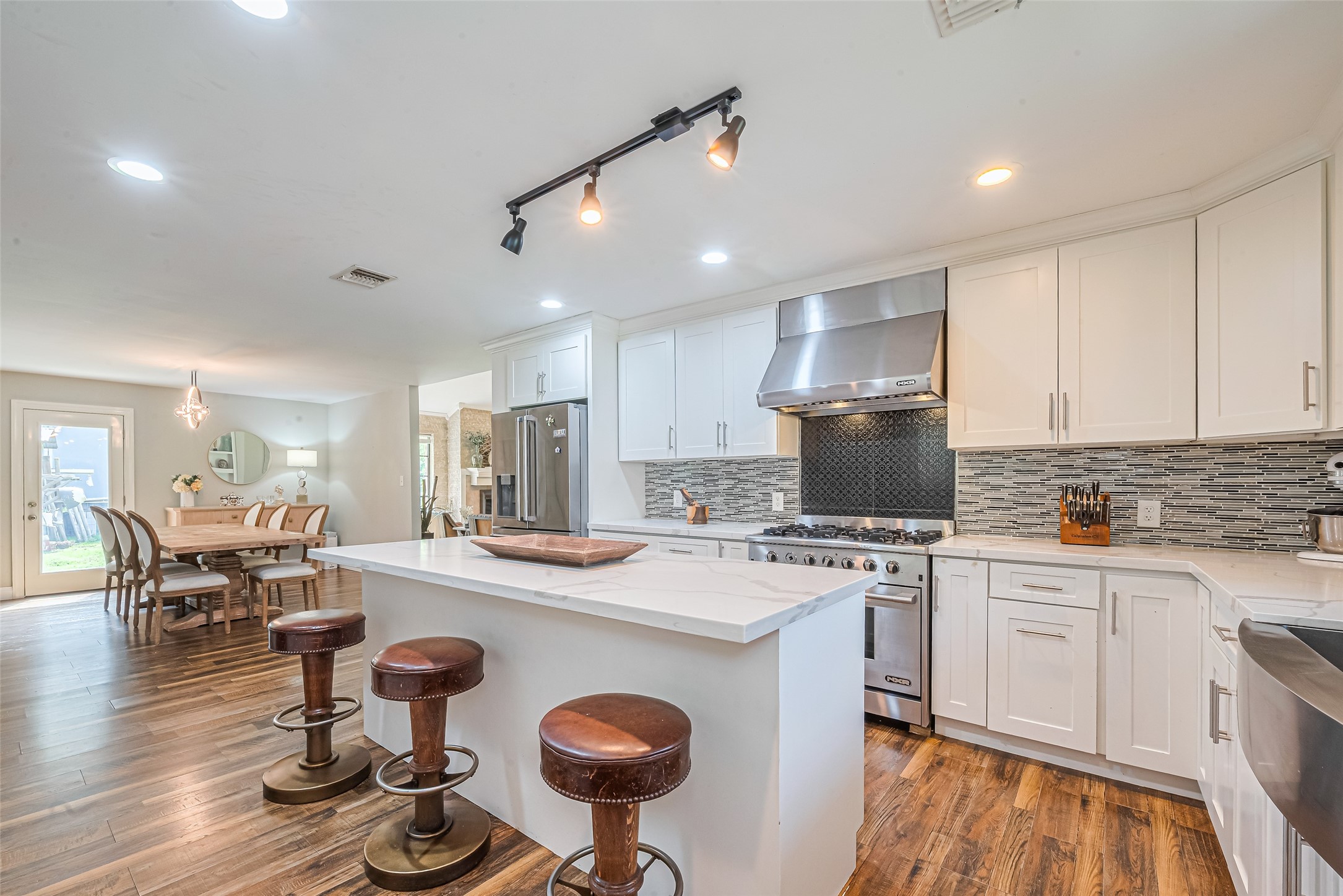 24314 Anderson Street Huffman, TX 77336 - Photo 25 of 48 a kitchen with a stove a refrigerator and a dining table with wooden floor