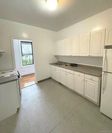 a kitchen with granite countertop white cabinets and white appliances