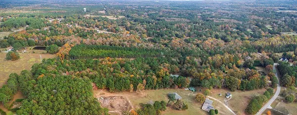 an aerial view of residential houses with outdoor space and trees