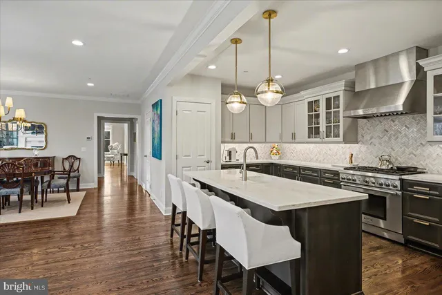 a kitchen with a dining table chairs stainless steel appliances and cabinets