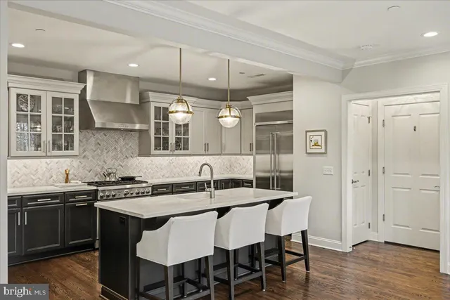 a kitchen with stainless steel appliances a sink stove and wooden floor