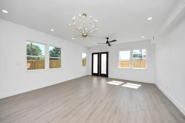 a view of a hallway with wooden floor and windows