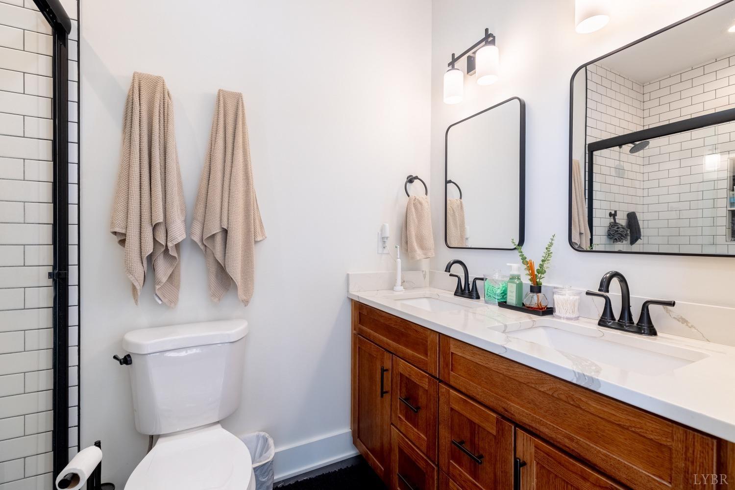 2142 Clarks Road Rustburg, VA 24588 - Photo 16 of 34 a bathroom with a double vanity sink toilet and a mirror