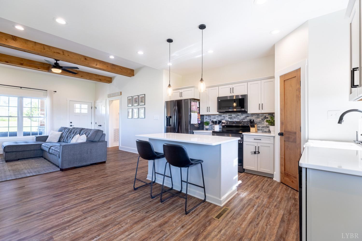 2142 Clarks Road Rustburg, VA 24588 - Photo 5 of 34 a kitchen with stainless steel appliances kitchen island granite countertop a stove a sink a refrigerator and white cabinets with wooden floor