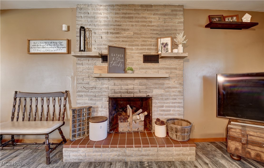 15235 Stocker Ridge Road Southwest Newcomerstown, OH 43832 - Photo 17 of 37 Living area featuring hardwood / wood-style floors and a brick fireplace